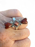 Making Waves Jewelry and Accessories artisan sterling silver ring with three red jasper stones and beadwork detailing.