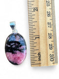 Making Waves Jewelry and Accessories oval rhodonite pendant with black and pink patterns in a sterling silver setting.