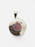 Making Waves Jewelry and Accessories round rose quartz pendant with a polished sterling silver frame on white background
