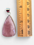 Making Waves Jewelry and Accessories teardrop rose quartz pendant in a polished sterling silver bezel next to a ruler.
