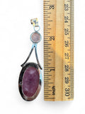 Making Waves Jewelry and Accessories rose quartz pendant with oval and round stones set in sterling silver next to ruler