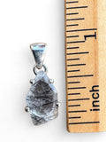 Making Waves Jewelry and Accessories rutilated quartz pendant in a sterling silver setting next to a ruler for scale.