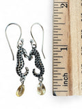Making Waves Jewelry and Accessories silver seahorse drop earrings with yellow crystal charms next to a ruler.