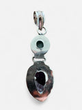 Back view of a Making Waves Jewelry and Accessories sterling silver pendant featuring Larimar and Amethyst stones.