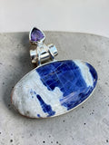 Making Waves Jewelry and Accessories artisan pendant with oval sodalite and triangular amethyst in sterling silver.