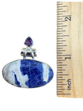 Making Waves Jewelry and Accessories sodalite and amethyst sterling silver pendant next to a wooden ruler for scale.