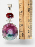 Making Waves Jewelry and Accessories solar quartz and red gemstone pendant in sterling silver next to a ruler.