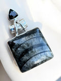 Making Waves Jewelry and Accessories square fossil pendant in sterling silver with a triangular black gemstone accent.