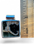 Making Waves Jewelry and Accessories square ocean jasper pendant in sterling silver next to a ruler for scale