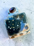 Making Waves Jewelry and Accessories square ocean jasper pendant with a red garnet accent in sterling silver setting.