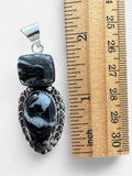 Making Waves Jewelry and Accessories artisan sterling silver pendant with black and white stone on a ruler for scale