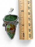 Making Waves Jewelry and Accessories artisan sterling silver pendant with green and amber natural stones next to a ruler
