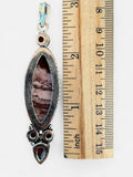 Making Waves Jewelry and Accessories artisan stone pendant with red carnelian accents and twisted silver detailing.