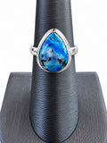Making Waves Jewelry and Accessories teardrop ring with a blue stone featuring dark inclusions in sterling silver.