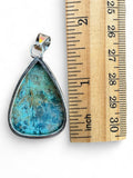 Making Waves Jewelry and Accessories teardrop gemstone pendant with teal stone and sterling silver bezel next to ruler