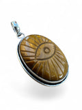 Making Waves Jewelry and Accessories oval Tiger's Eye pendant with a carved evil eye motif in sterling silver setting.