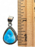 Making Waves Jewelry and Accessories teardrop turquoise pendant in 925 sterling silver with rope border next to a ruler