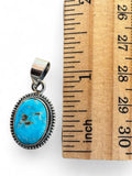 Making Waves Jewelry and Accessories oval turquoise pendant in 925 sterling silver with a beaded border next to a ruler