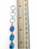 Making Waves Jewelry and Accessories oval copper turquoise and sterling silver link bracelet next to a wooden ruler.