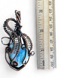 Making Waves Jewelry and Accessories handcrafted wire-wrapped pendant with a blue gemstone and oxidized copper wire.